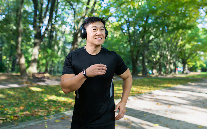 Asian-man-jogging-in-park-after-recovering-from-back-injury